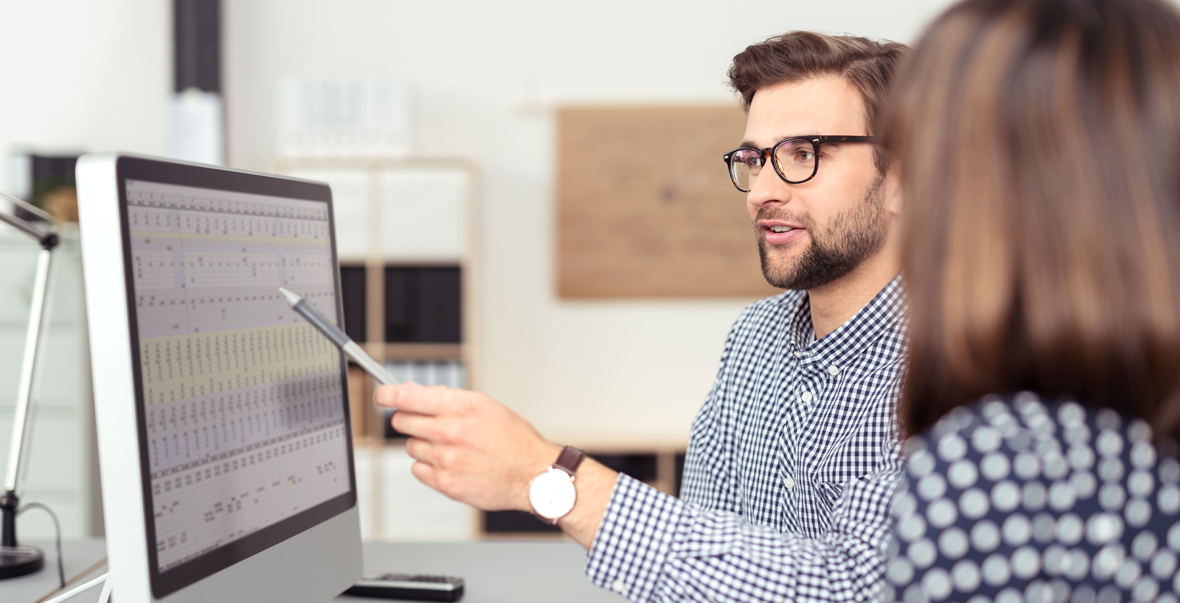 man with glasses reviewing computer data